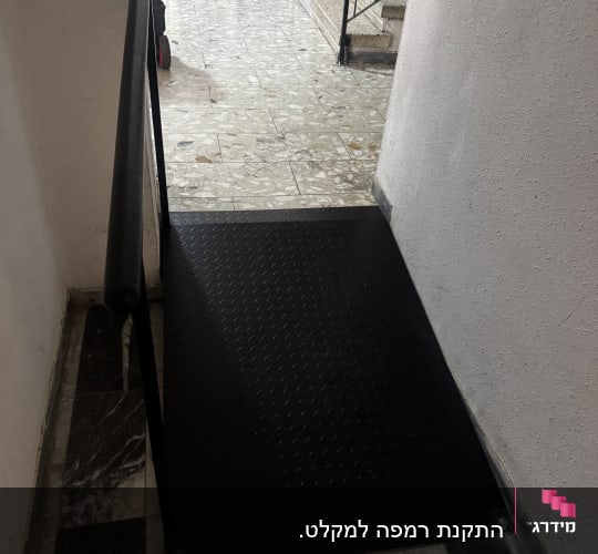 רמפה שחורה עם מעקה במסדרון פנימי